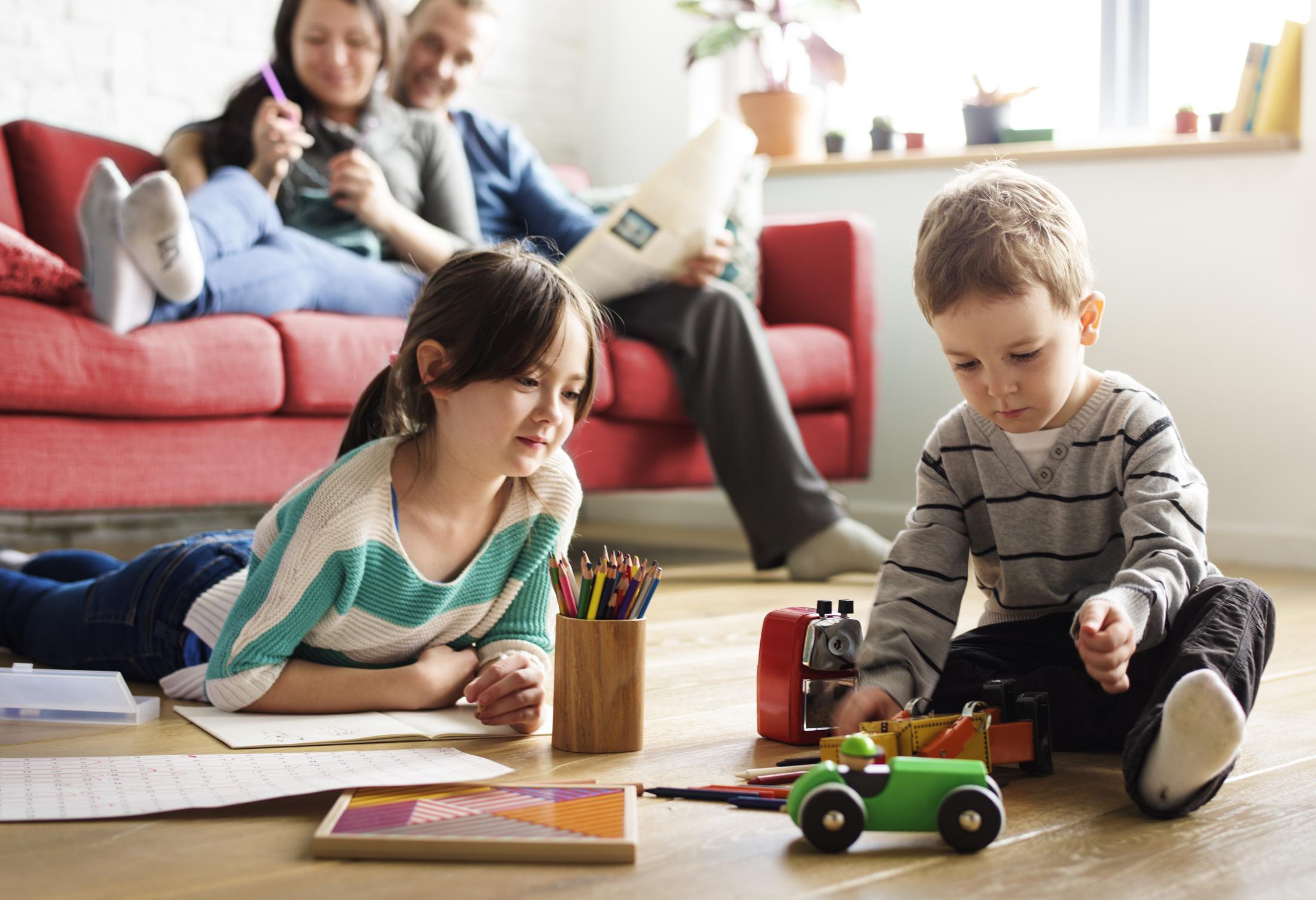 Two children playing and parents in the background